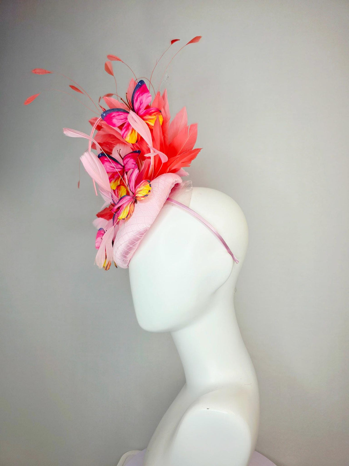 kentucky derby hat fascinator light pink satin with netting baby pink coral orange branching feathers and pink yellow navy blue butterflies