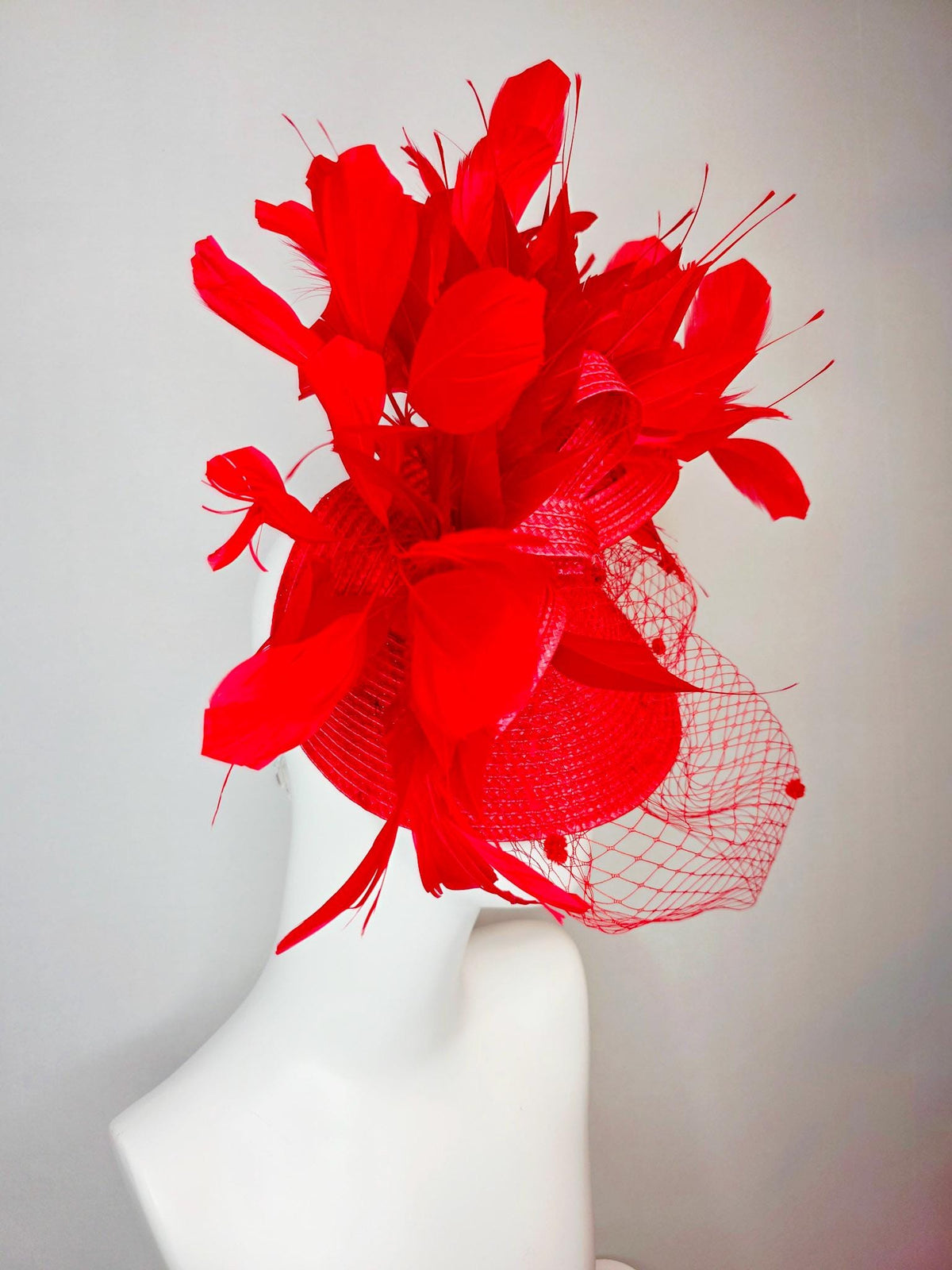 kentucky derby hat fascinator scarlet red straw saucer with red straw bow with bright red branching feathers and red mesh veil