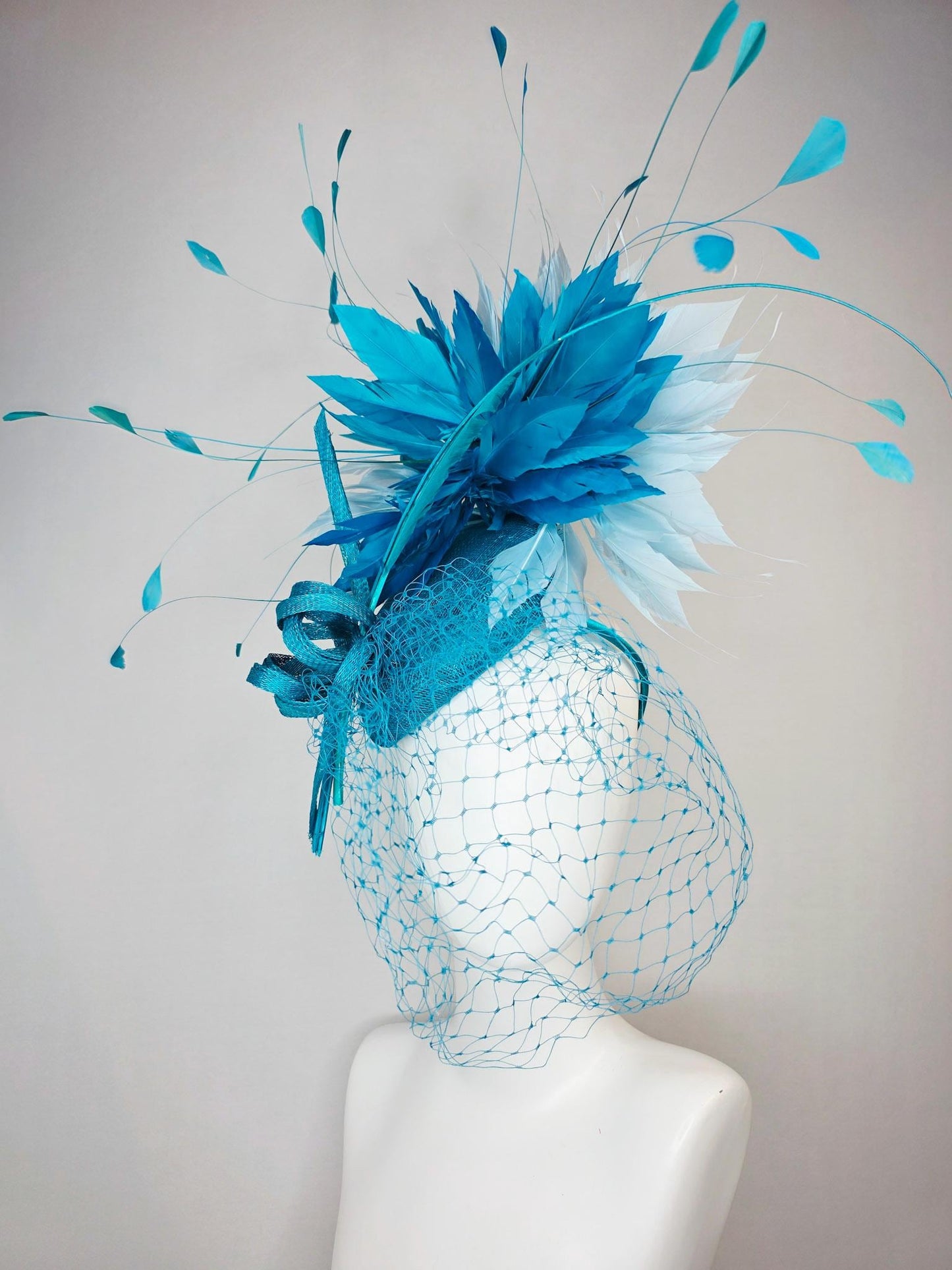 kentucky derby hat fascinator sky blue sinamay with sinamay bow and sky teal and light blue feathers and blue mesh veil