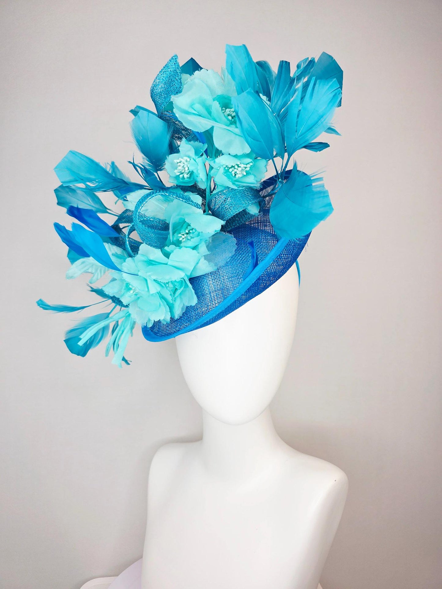 kentucky derby hat fascinator turquoise blue sinamay saucer with bow aqua blue organza satin flowers sky and royal blue branching feathers