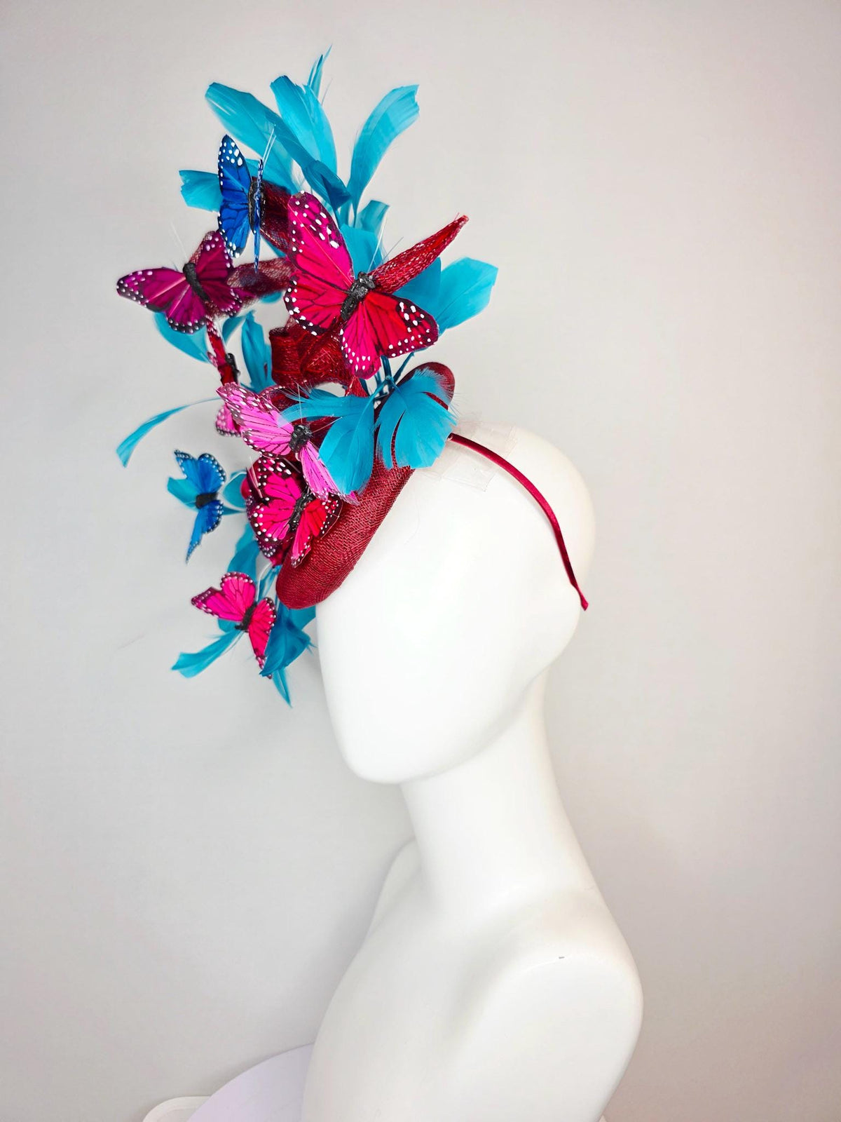 kentucky derby hat fascinator burgundy red sinamay with curls wine red organza flower turquoise sky blue feathers blue pink red butterflies