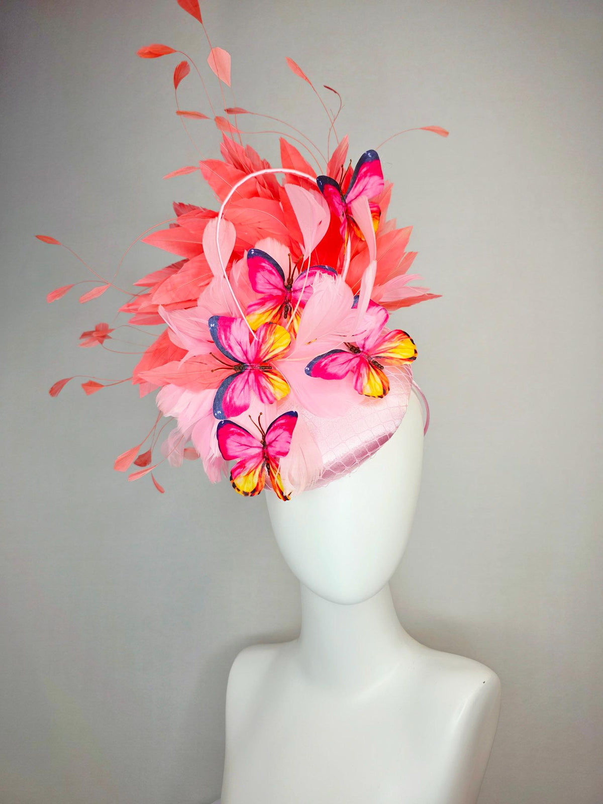 kentucky derby hat fascinator light pink satin with netting baby pink coral orange branching feathers and pink yellow navy blue butterflies
