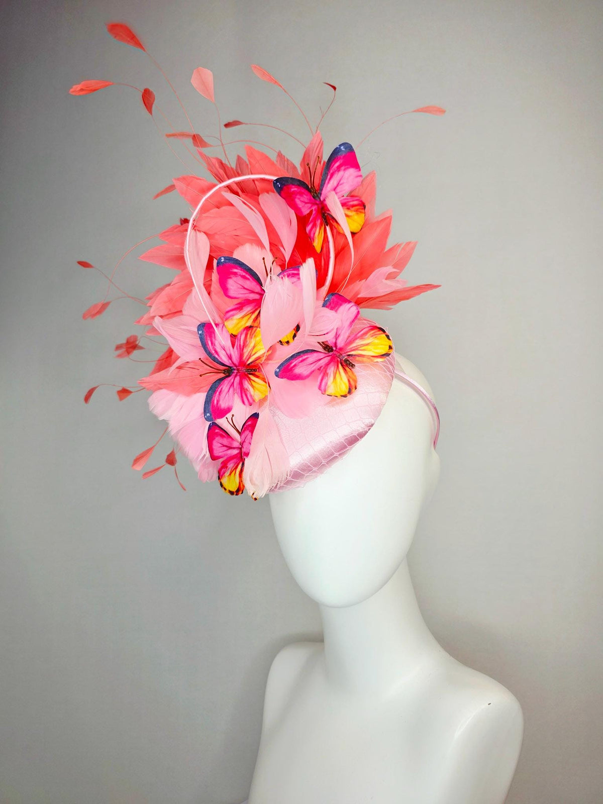 kentucky derby hat fascinator light pink satin with netting baby pink coral orange branching feathers and pink yellow navy blue butterflies