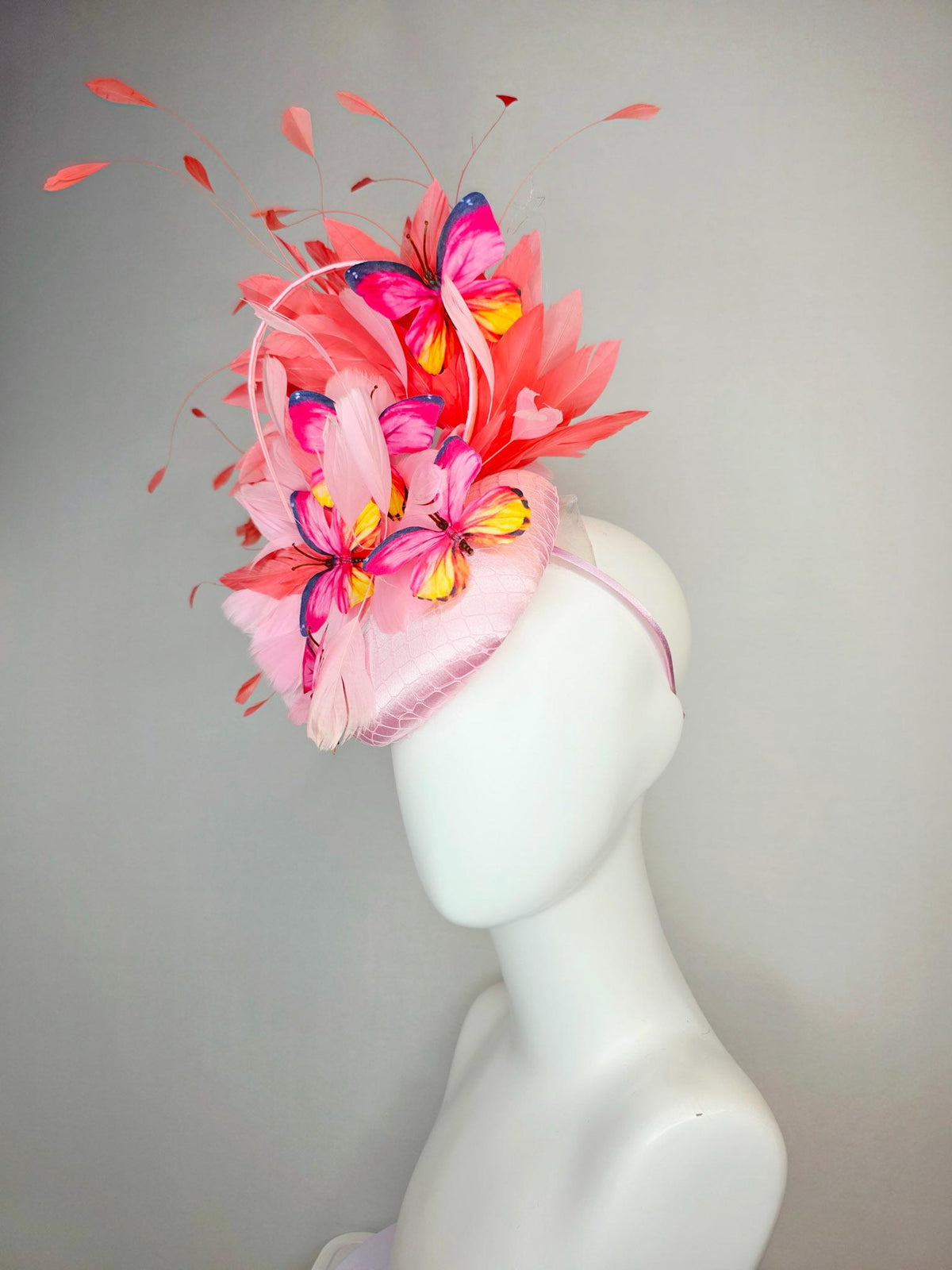 kentucky derby hat fascinator light pink satin with netting baby pink coral orange branching feathers and pink yellow navy blue butterflies