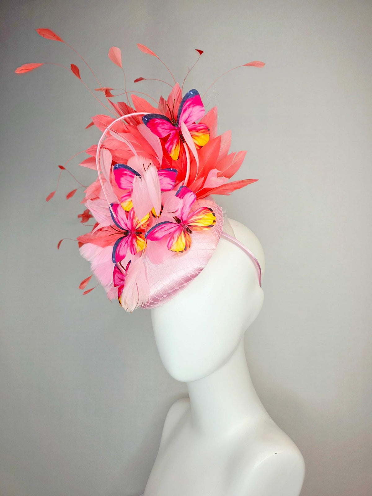kentucky derby hat fascinator light pink satin with netting baby pink coral orange branching feathers and pink yellow navy blue butterflies