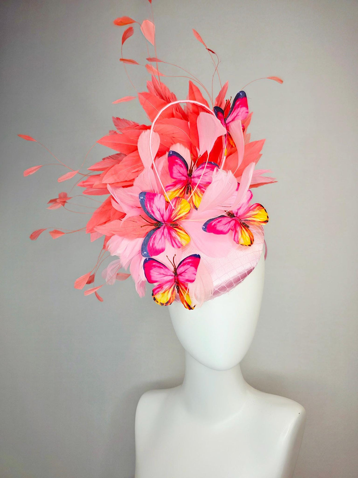 kentucky derby hat fascinator light pink satin with netting baby pink coral orange branching feathers and pink yellow navy blue butterflies