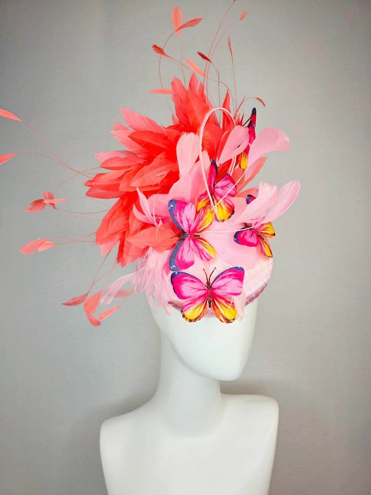 kentucky derby hat fascinator light pink satin with netting baby pink coral orange branching feathers and pink yellow navy blue butterflies