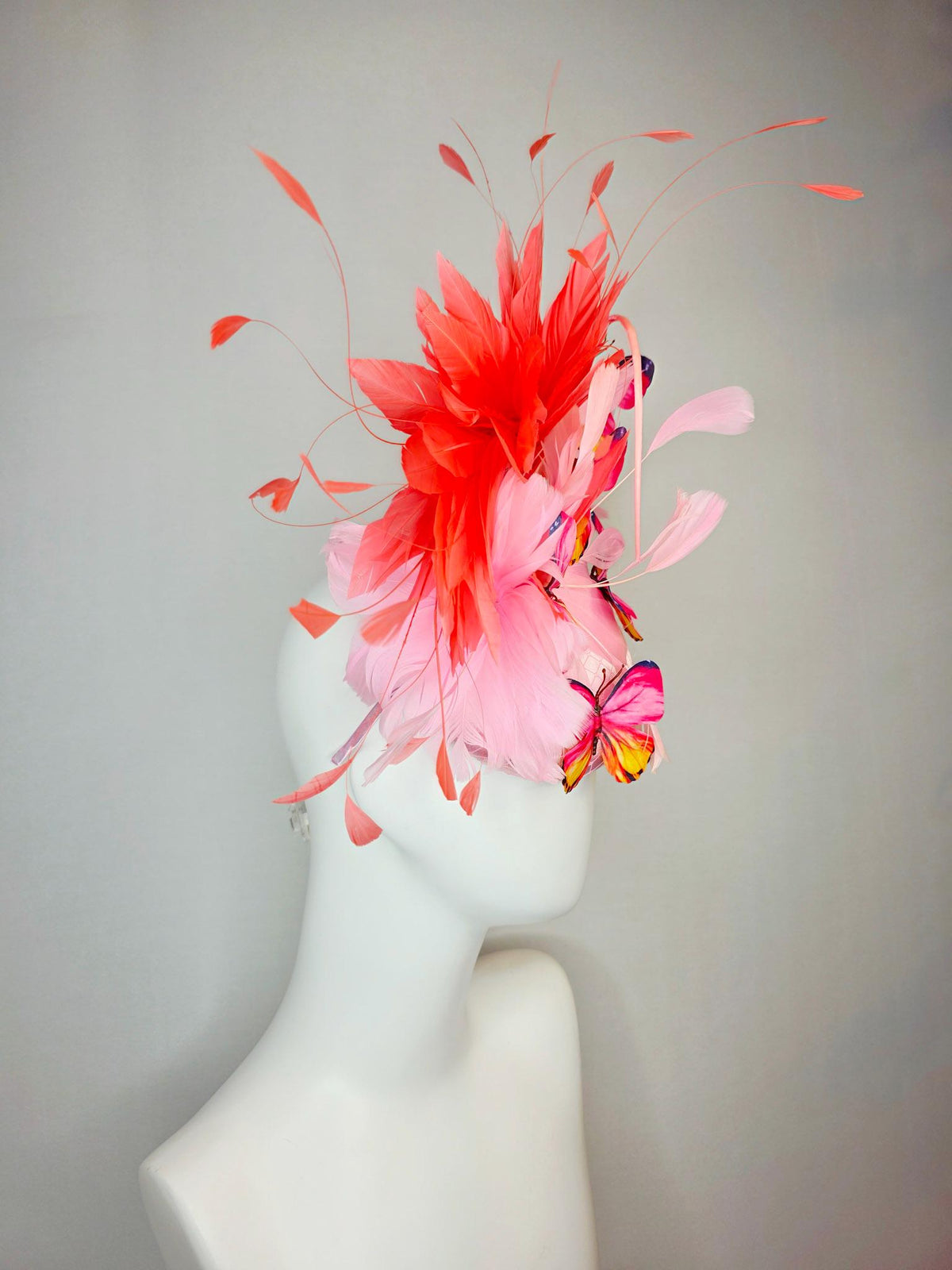 kentucky derby hat fascinator light pink satin with netting baby pink coral orange branching feathers and pink yellow navy blue butterflies