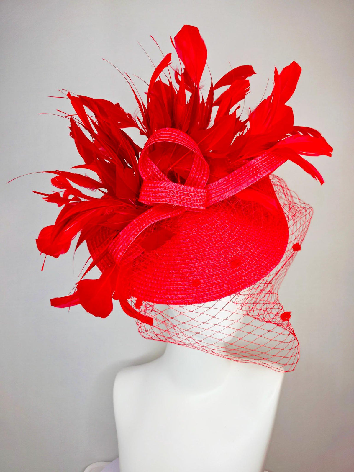 kentucky derby hat fascinator scarlet red straw saucer with red straw bow with bright red branching feathers and red mesh veil