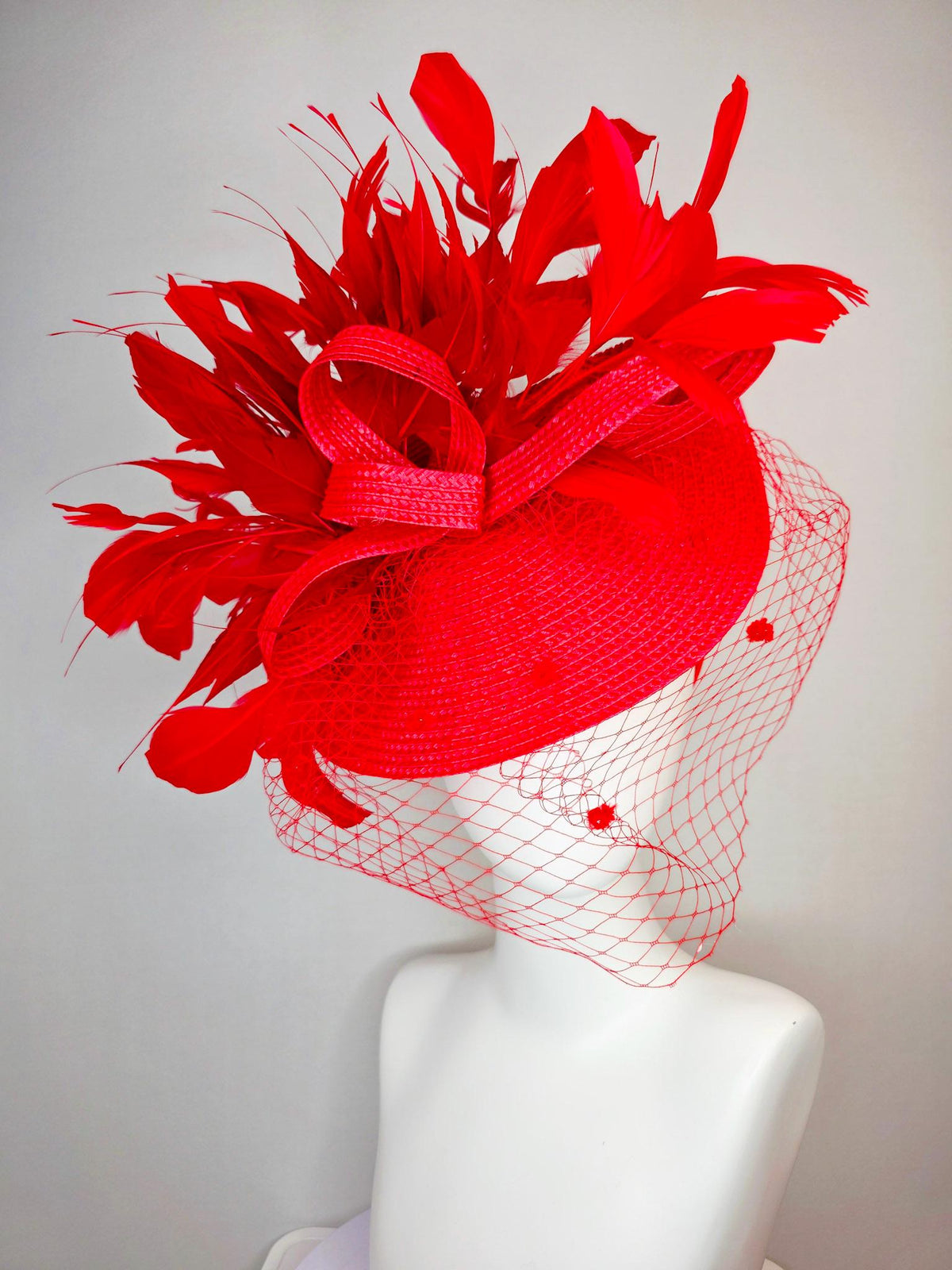 kentucky derby hat fascinator scarlet red straw saucer with red straw bow with bright red branching feathers and red mesh veil